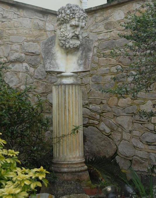Antique bust on plinth with lichens and patina